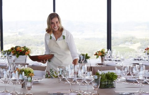 Director of Hospitality Nitsa Knoll setting glasses on dining table for Jordan's annual Sunset Supper at Vista Point