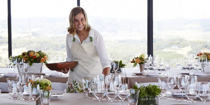 Director of Hospitality Nitsa Knoll setting glasses on dining table for Jordan's annual Sunset Supper at Vista Point