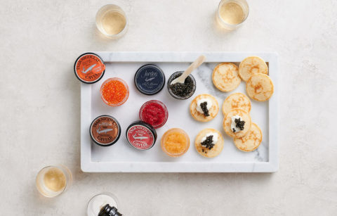 caviar and gourmet roes on white background with champagne