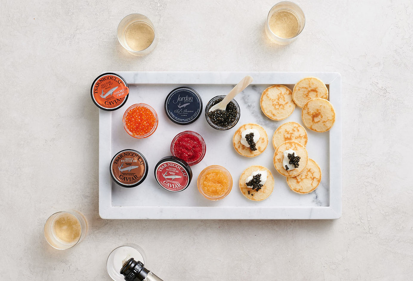 caviar and gourmet roes on white background with champagne