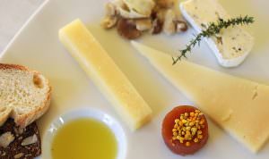 close up of cheese plate with quince paste topped with bee pollen and extra virgin olive oil