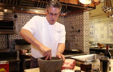 Jordan Winery Executive Chef Todd Knoll mashing herbs with a mortar and pestle in Jordan Winery Kitchen