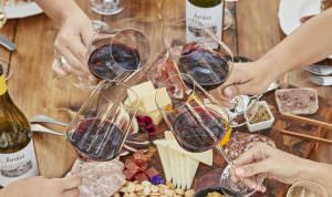 hands toasting with glasses of Jordan Winery Cabernet with charcuterie and cheese plate in background