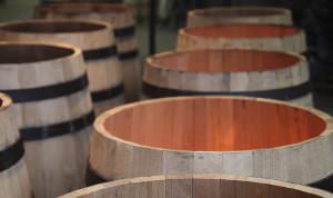 open topped wine barrels over flames at a cooperage