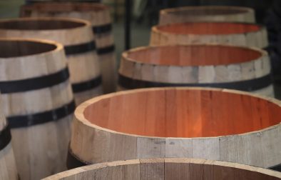 open topped wine barrels over flames at a cooperage