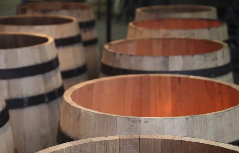 open topped wine barrels over flames at a cooperage