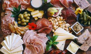 close up of a charcuterie and cheese board with marcona almonds and olives