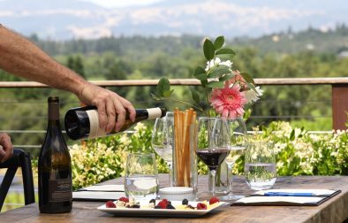 hands pouring wine at a table setting at Flanagan Winery's Cheese Pairing Wine Tasting