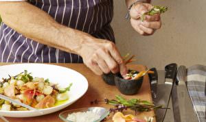 close up of Chef adding garnish to a plated appetizer