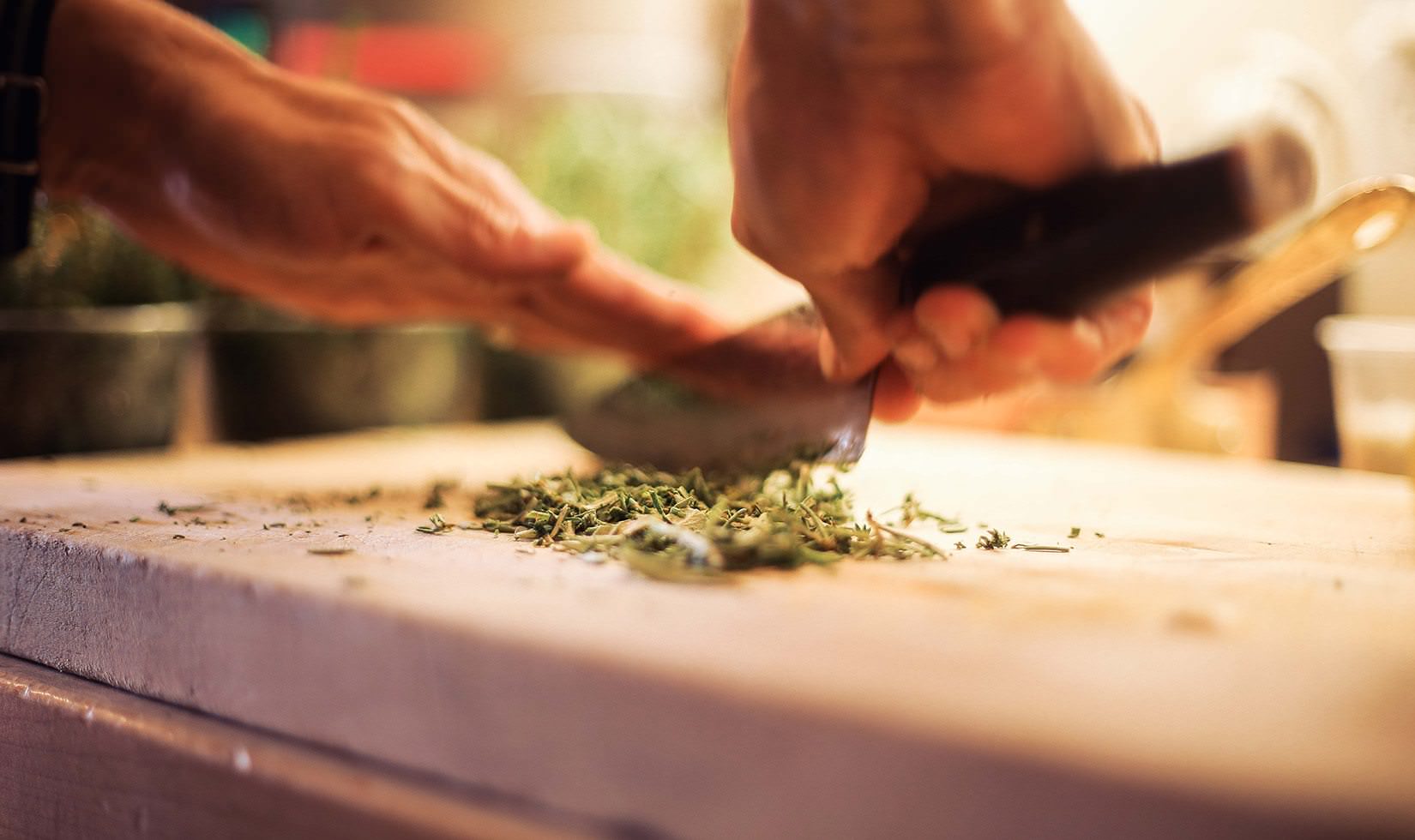 person holding a knife and slicing some spices