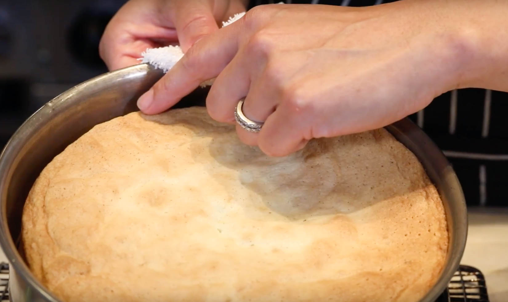 hands pointing to the edge of olive oil cake pan