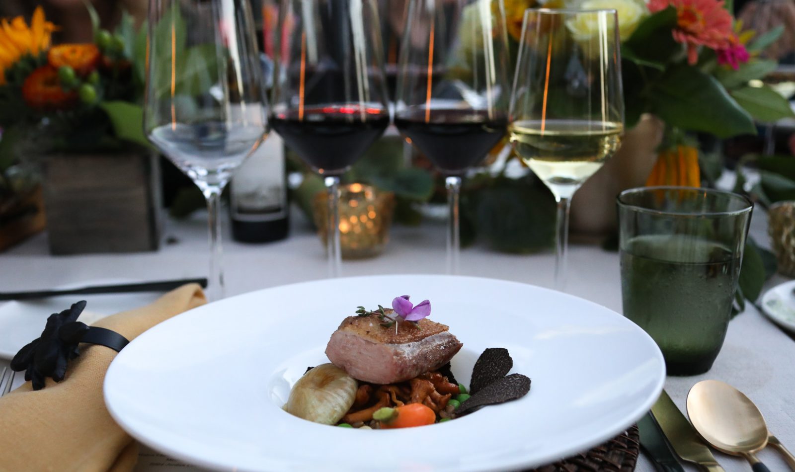 place setting with entree and wine flight at Bounty Summer Dinner at Jordan Winery