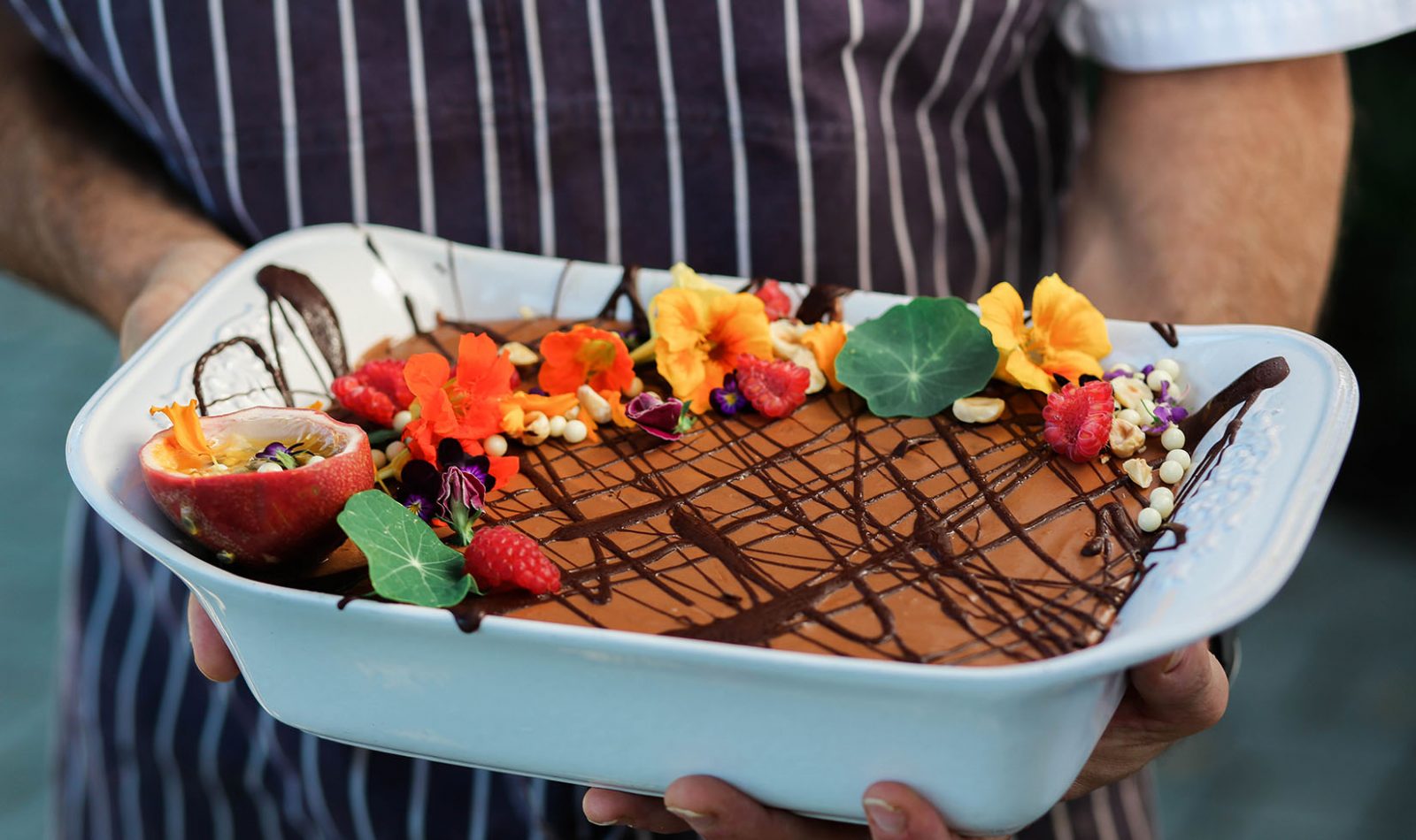 Jordan Winery chocolate mousse with edible flowers held by Jordan Winery Executive Chef Todd Knoll