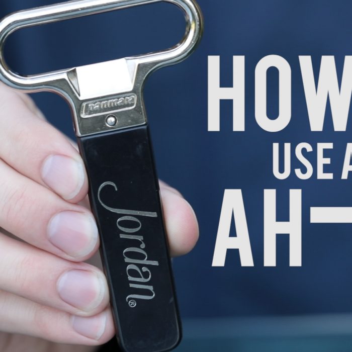 hand holding a Jordan Winery logo ah-so wine bottle opener with image text "how to use an ah-so"