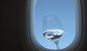 Glass of Chardonnay with airplane window in background