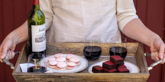 tray of desserts and Jordan Cabernet being held by someone in a Jordan cooking apron