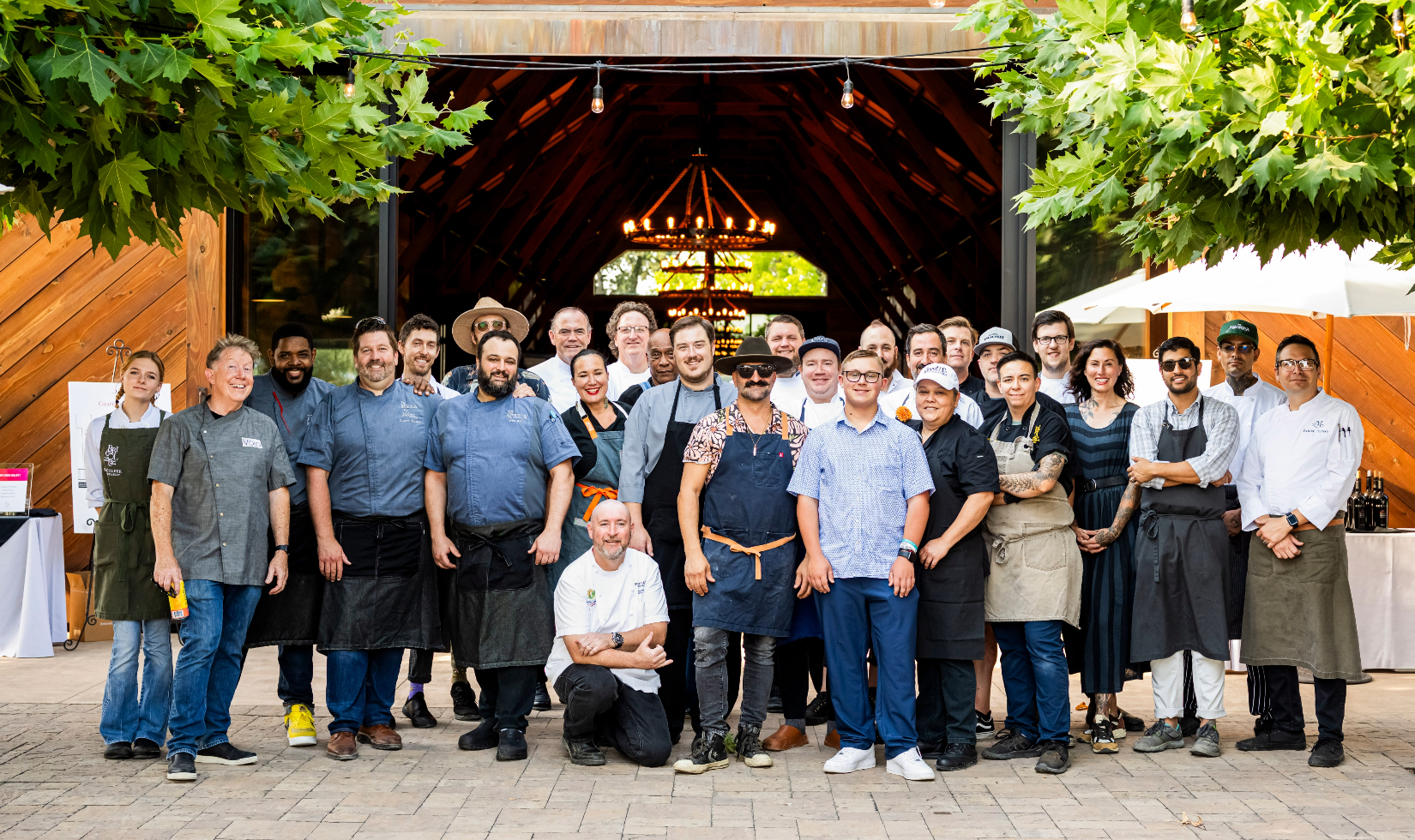 Winery team dressed in work clothes and uniforms standing on a terrace outside of the winery dining room.