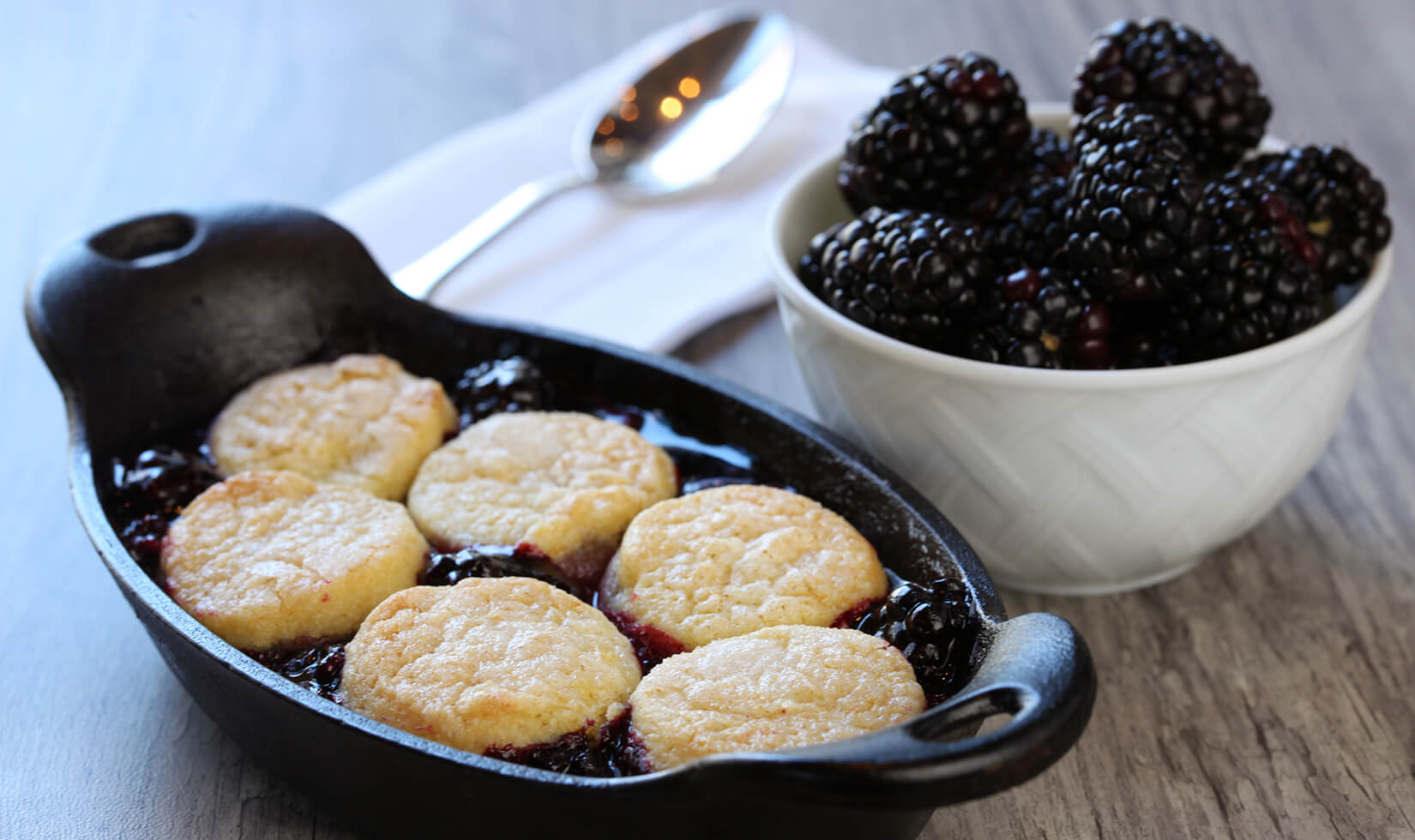 Jordan Winery Blackberry Cobbler next to a bowl of blackberries