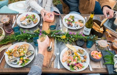 Full plates with crab salad, potatoes, salmon rillette and more at a coastal picnic