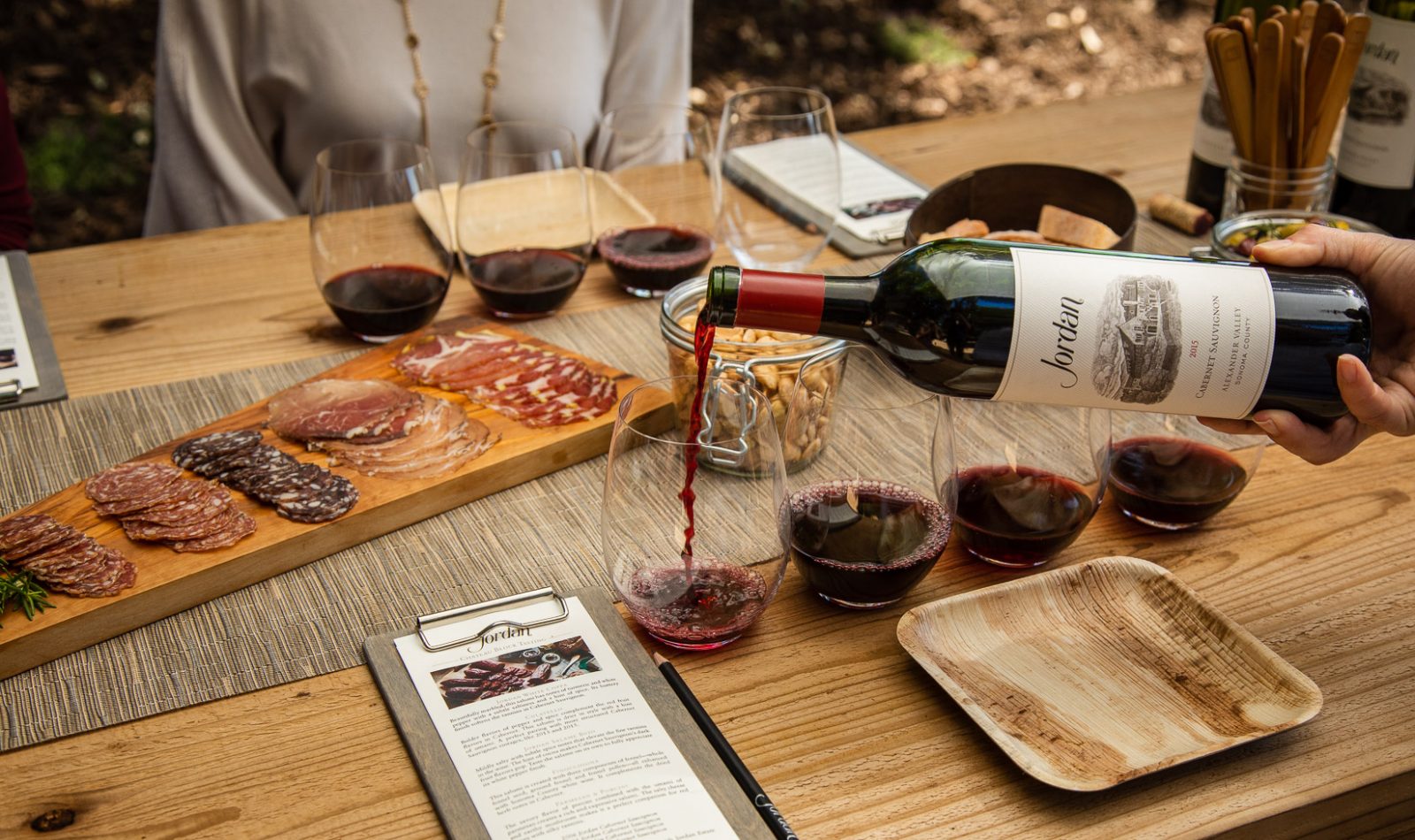 Jordan Winery chateau block table setting with charcuterie and hand pouring Jordan Cabernet for red wine flight