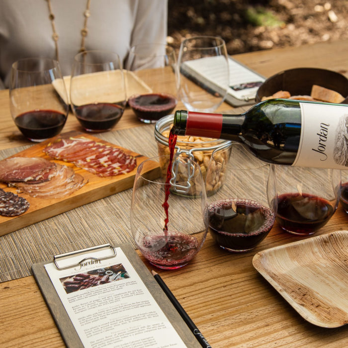 Jordan Winery chateau block table setting with charcuterie and hand pouring Jordan Cabernet for red wine flight