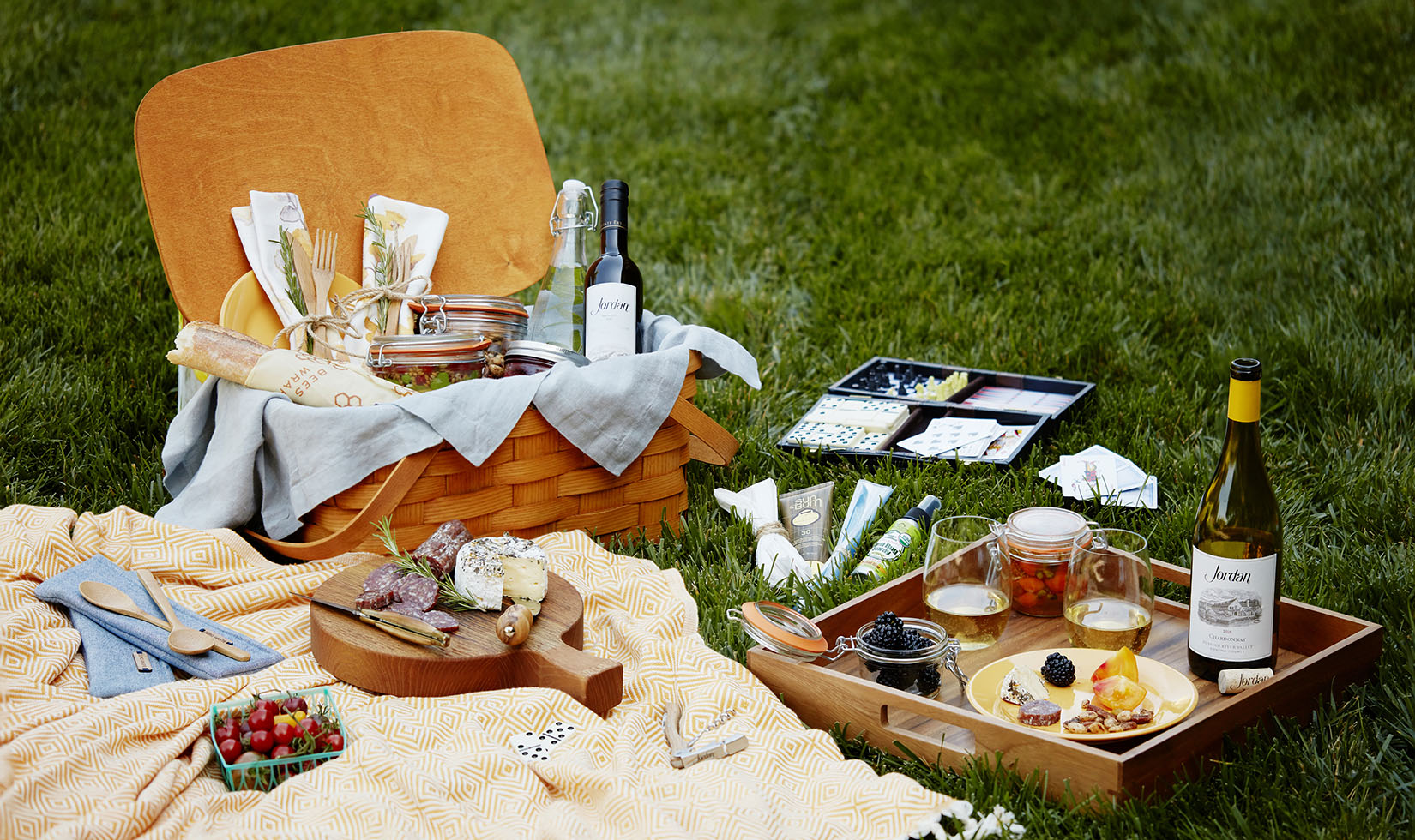 The ultimate picnic basket on the lawn with cheese, charcuterie, games and Jordan Chardonnay.