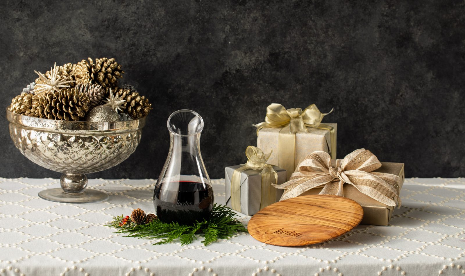 Jordan wine decanter, olive wood cheese board and presents on a table