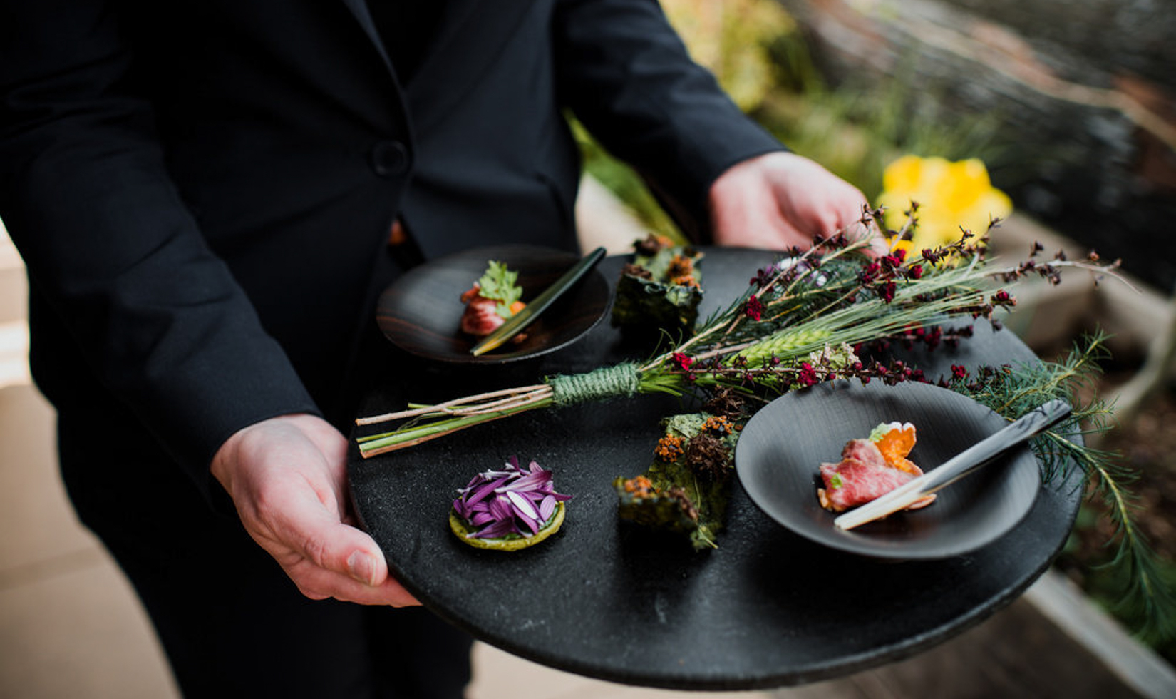 server holding a platter of small bites on healdsburg rooftop