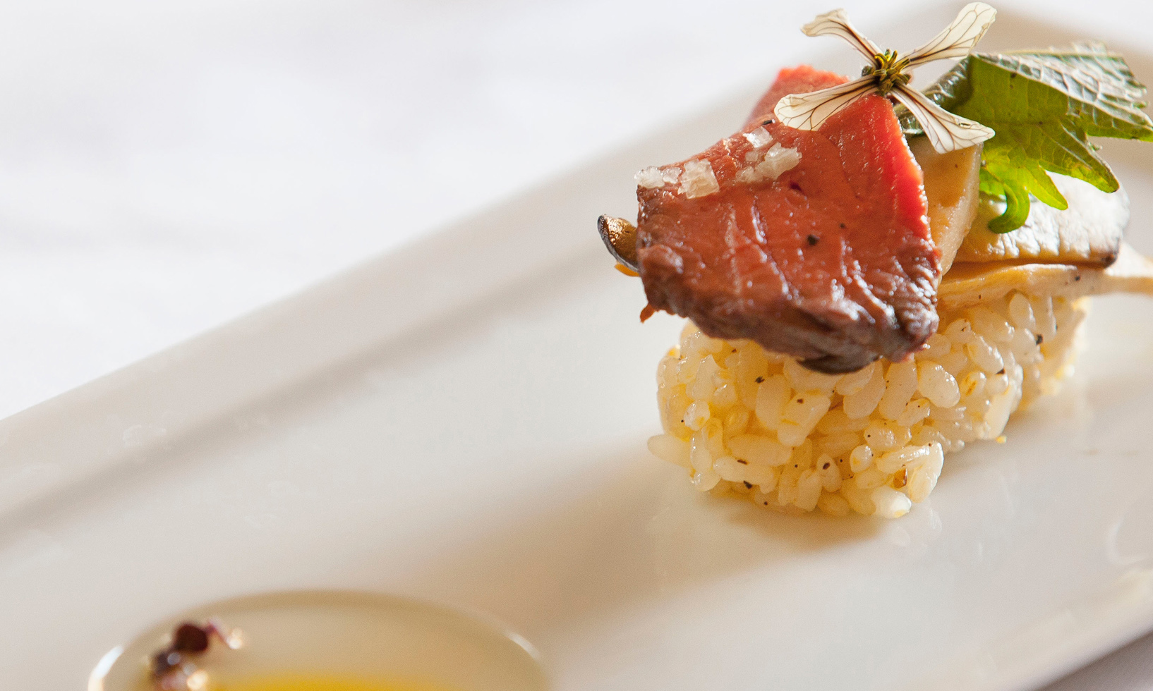 close up of Jordan Winery strip steak on sushi rice with mushroom