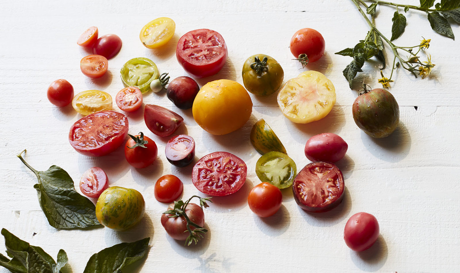 A variety of heirloom tomatoes on a white board