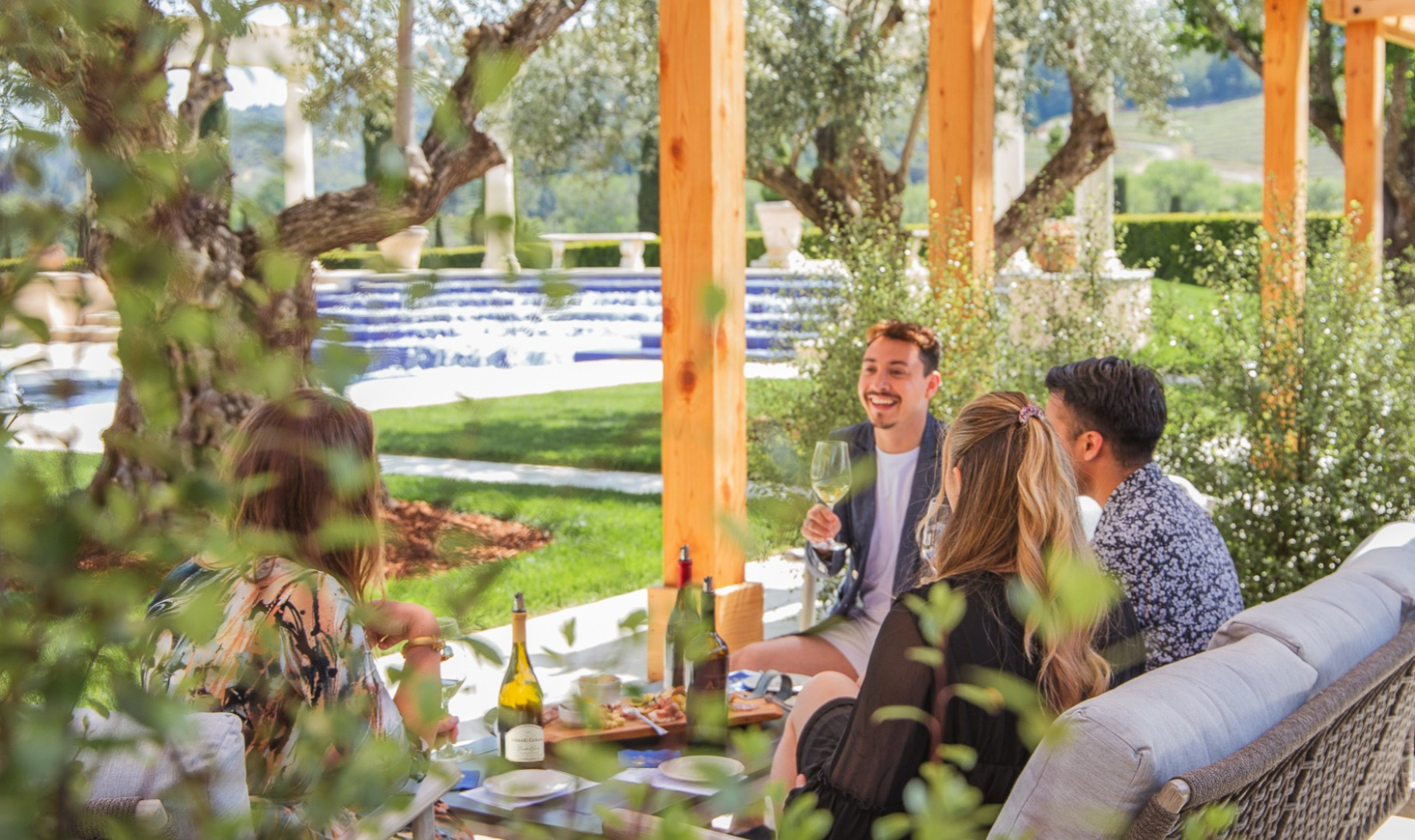 Outdoor Wine Tastings group sitting under pergola drinking wine