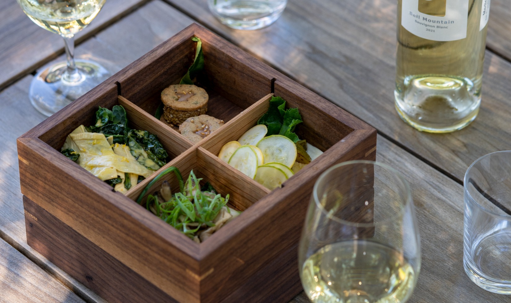 Outdoor Wine Tastings bento box lunch with glass of sauvignon blanc