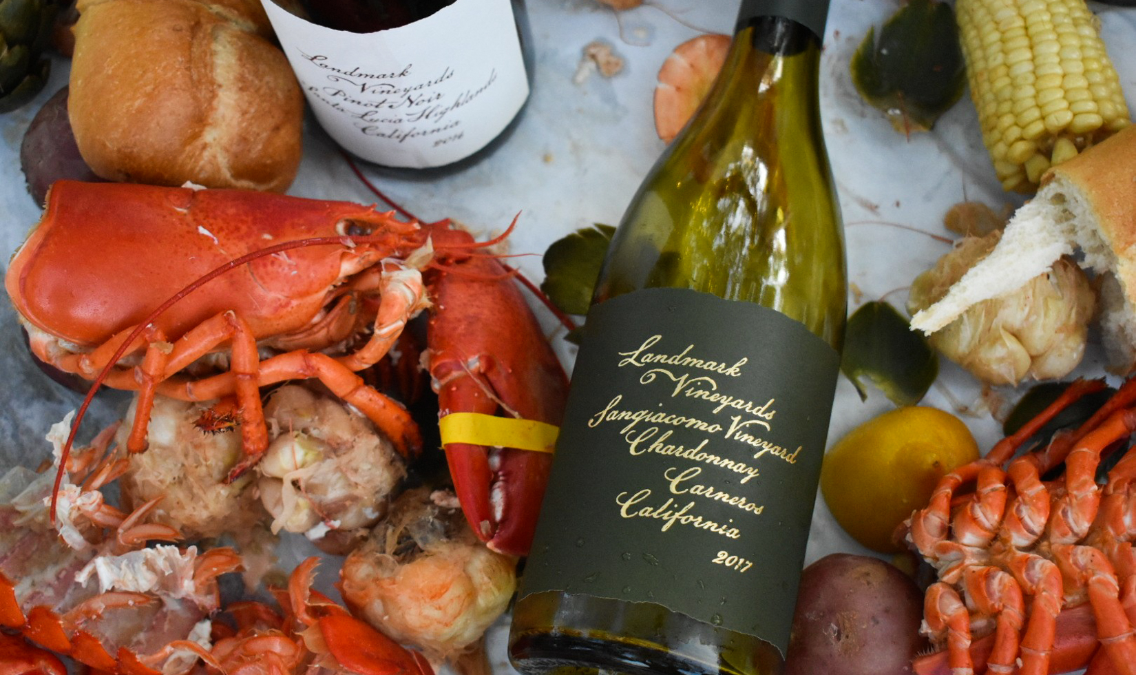 chardonnay wine bottle with lobster and corn for summer dinner