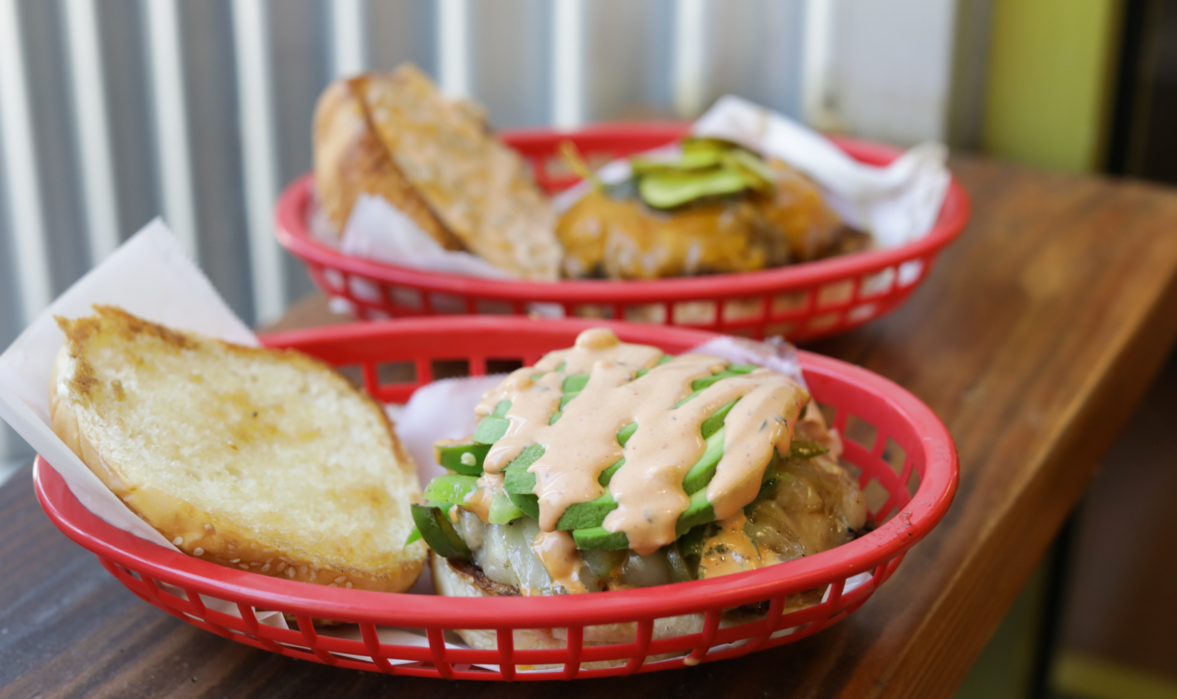 two cheeseburgers set in red baskets at restaurant