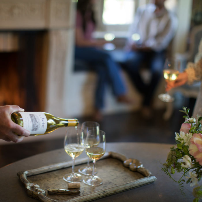 chardonnay pouring in wine glass with fireplace in the background