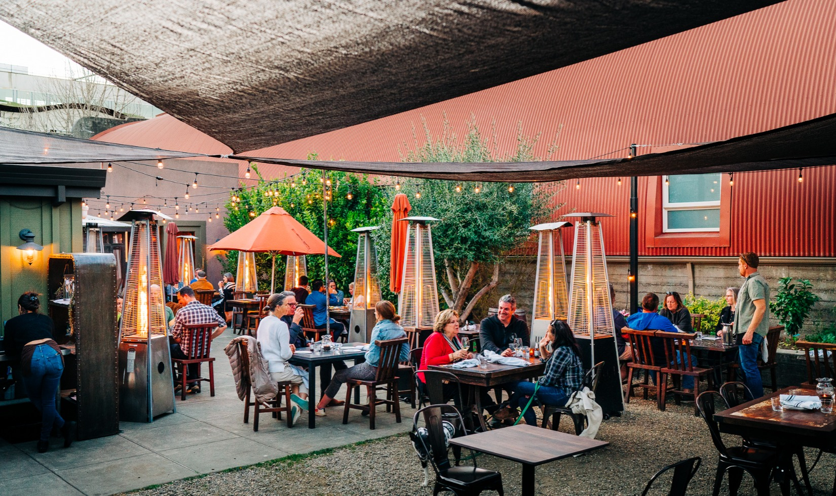 Diners sit around outside patios table on the outdoor terrace at Lo and Behold.