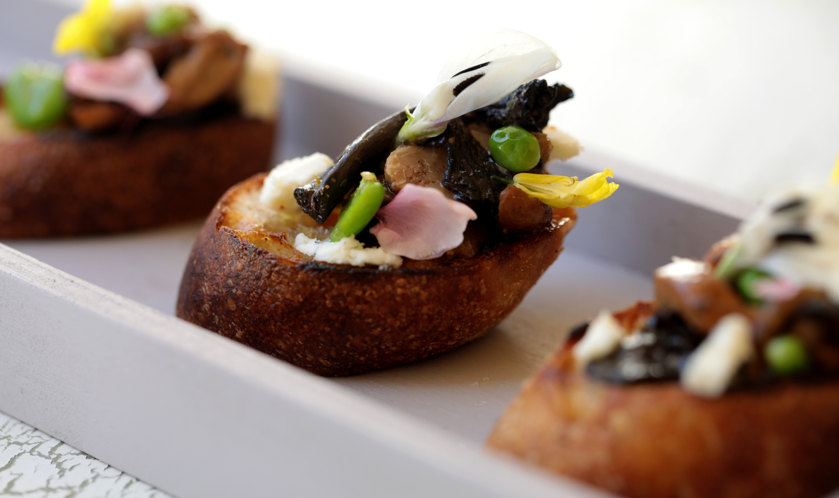 mushroom and pea shoots on a toasted crostini bread