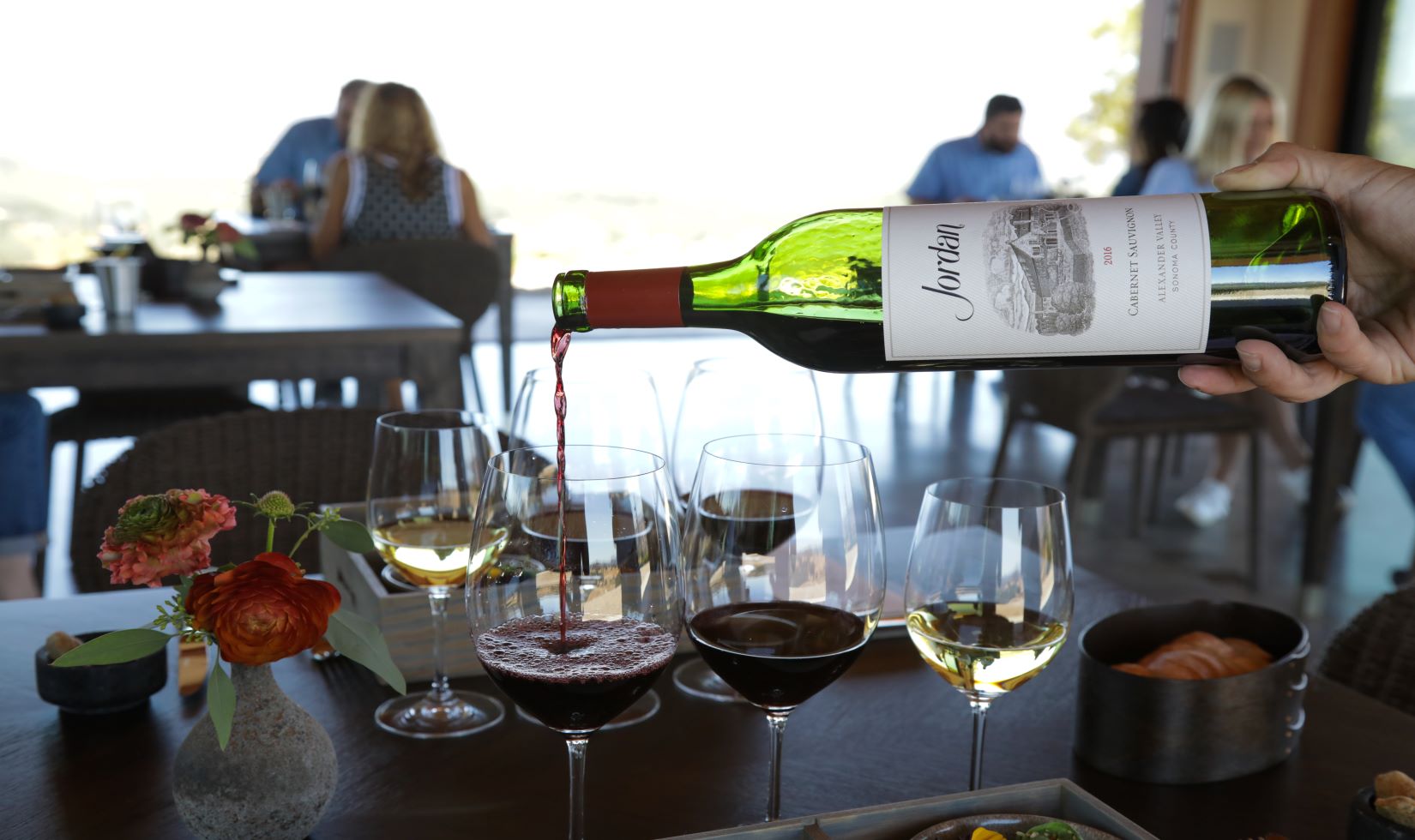 Cabernet Sauvignon poured into glass with vista view outside of large windows