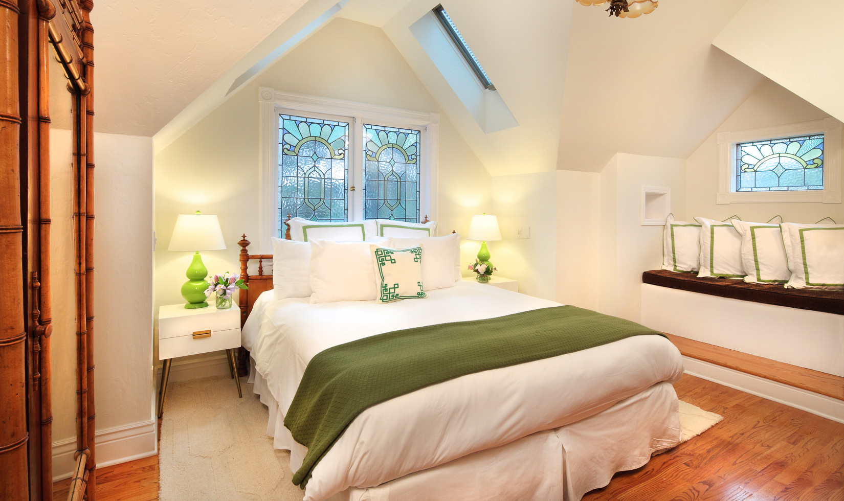 Cozy attic bedroom with stained glass windows.