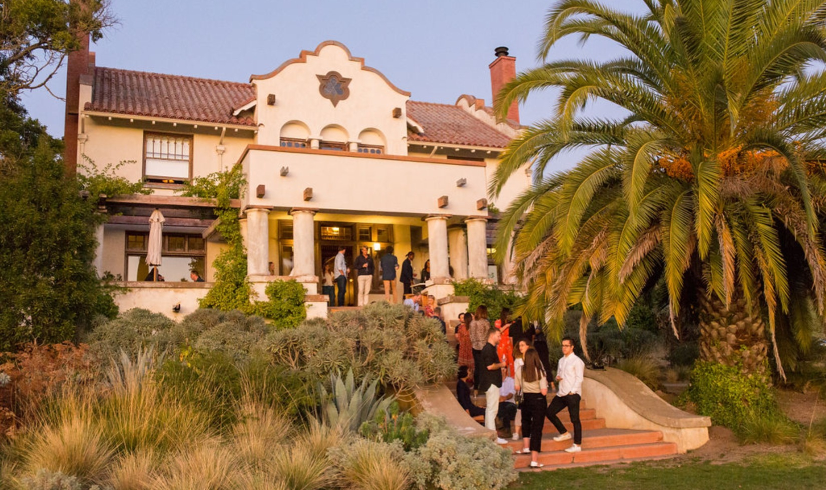 Group walking up outdoor stairs towards the front door the Hacienda building at Scribe Winery