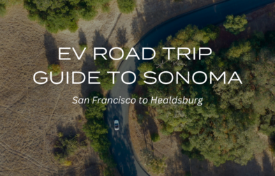 white text overlay on aerial view of a white car driving through road near oak trees