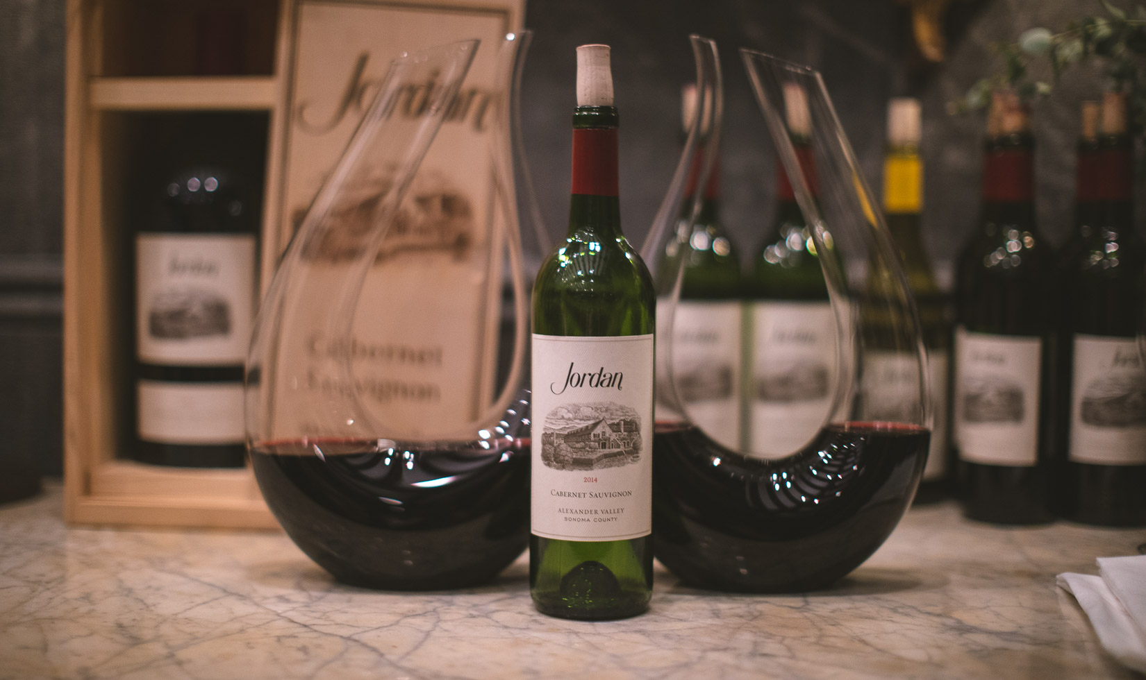 bottle of cabernet with two glass decanters in the background 
