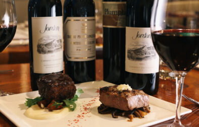 bottles of cabernet on restaurant table with cuts of steak