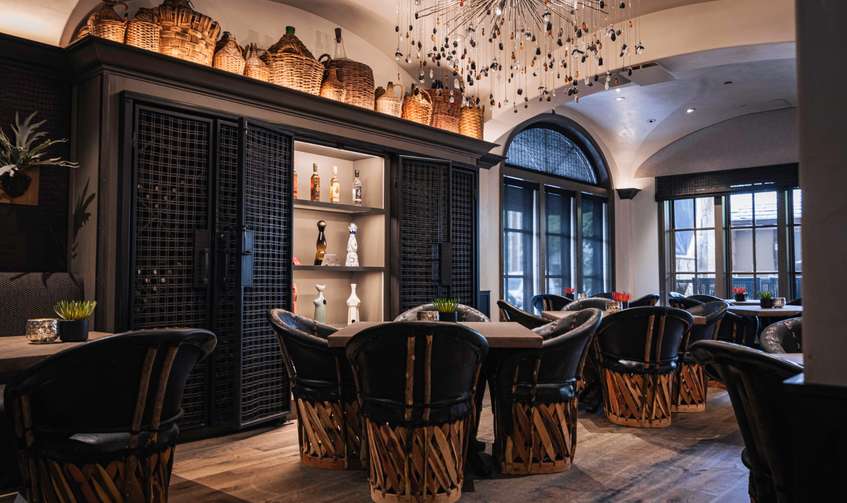 interior of arandas restaurant dining room featuring four-top tables in renovated space with tequila displayed on shelves