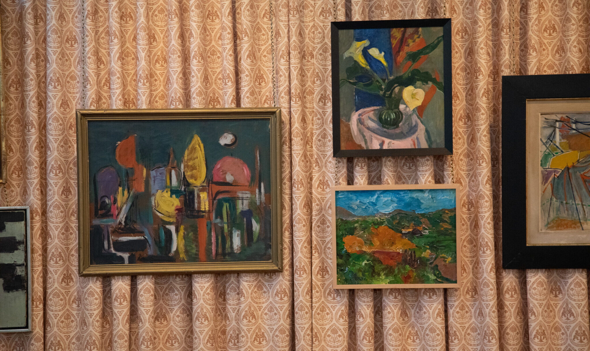 framed paintings hung on in front of wall covered with curtain