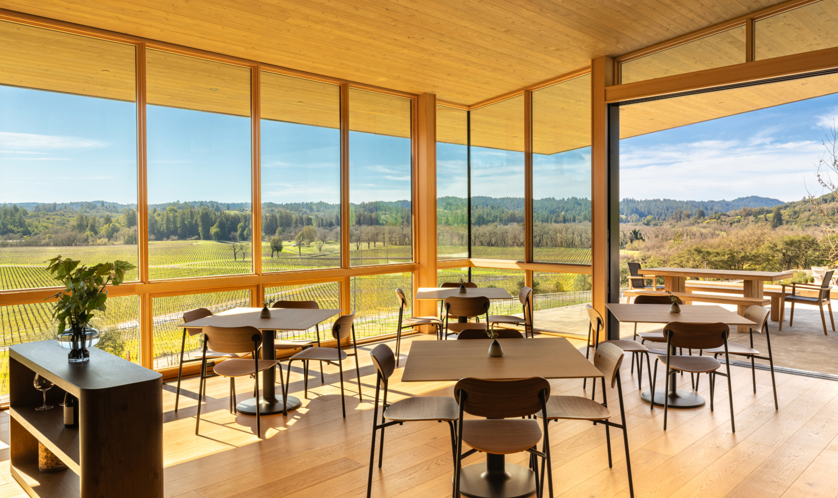 Interior of Auteur Winery tasting with floor to ceiling windows overlooking vineyard