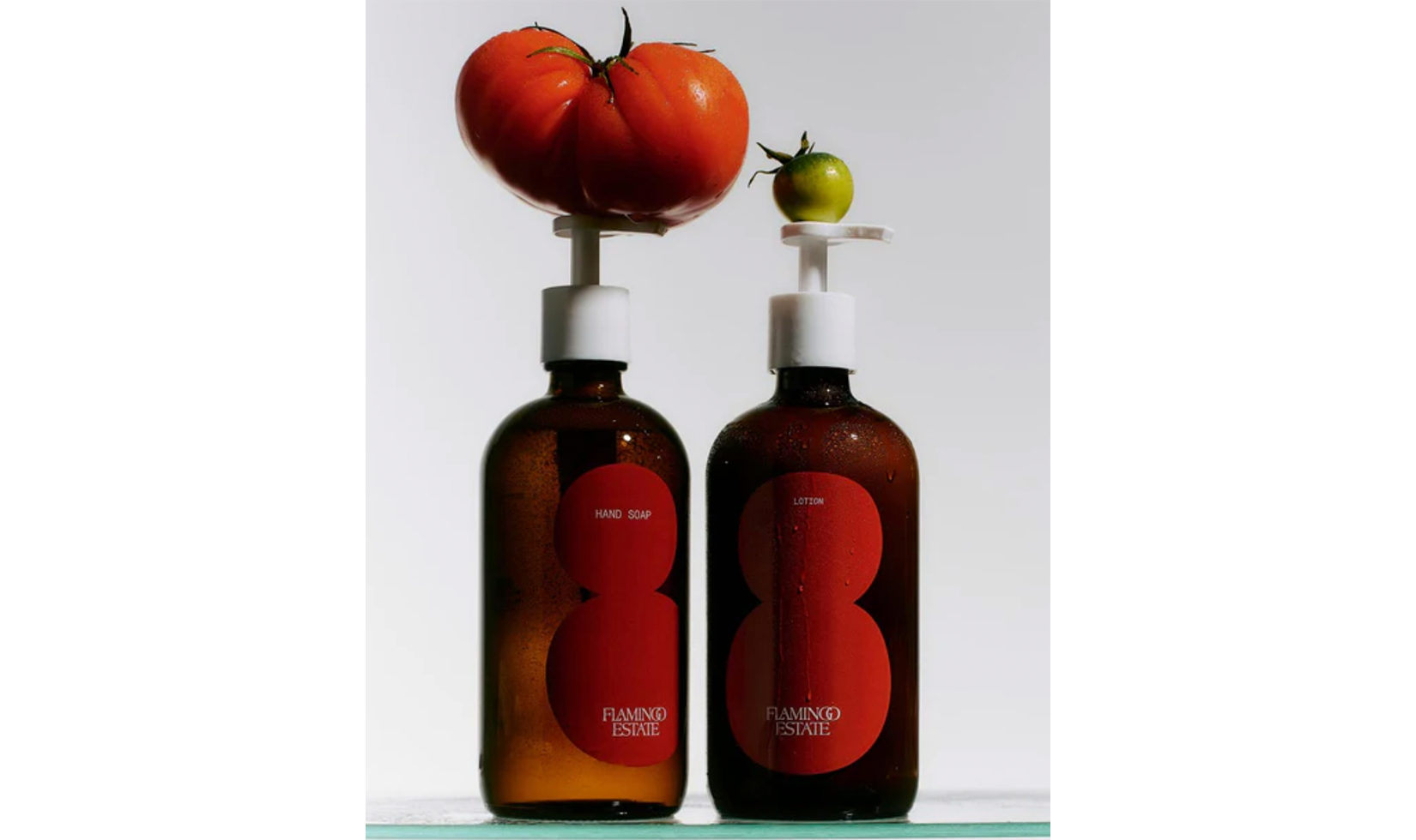 Flamingo Estate hand soap and lotion bottles with tomatoes on top.