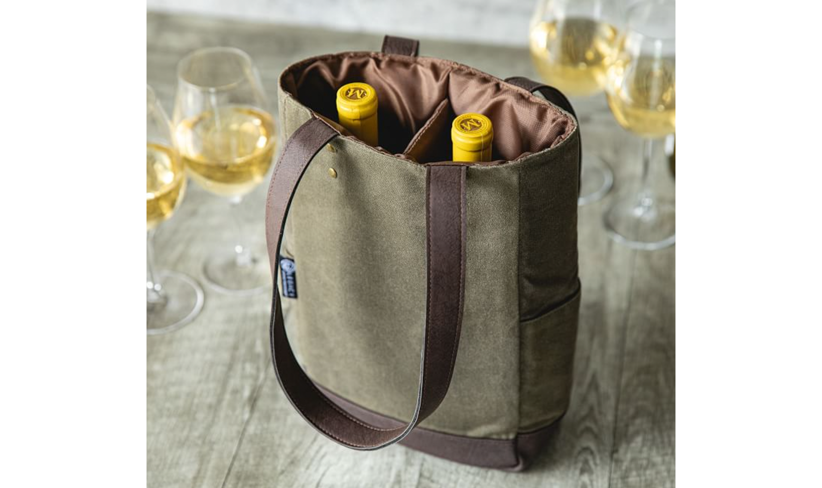 Olive green wine tote with two bottles inside, surrounded by wine glasses.