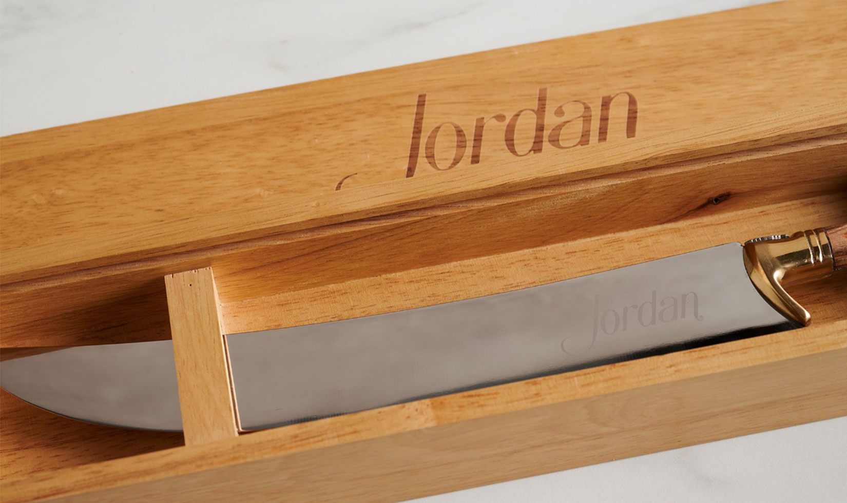 Engraved wooden box with a Jordan-branded knife inside.
