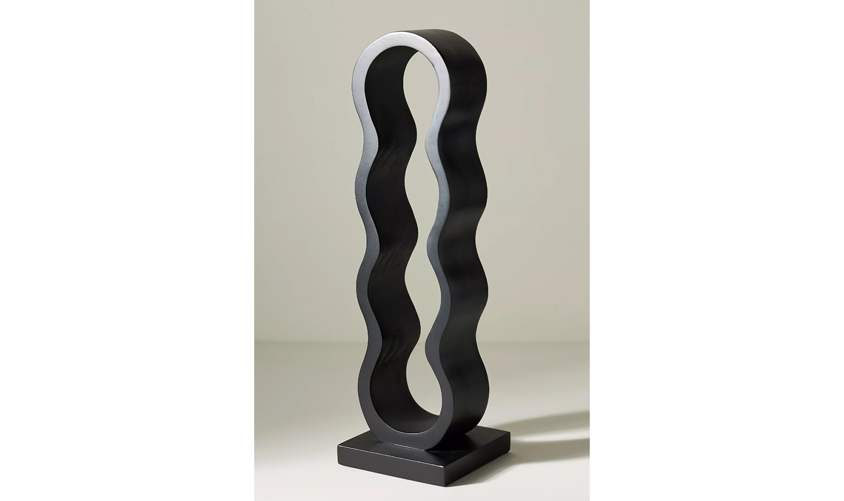 Black wavy metal wine bottle holder with a modern design.